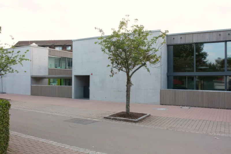 Ansicht des Gebäudes von der Straße mit Baum im Vordergrund