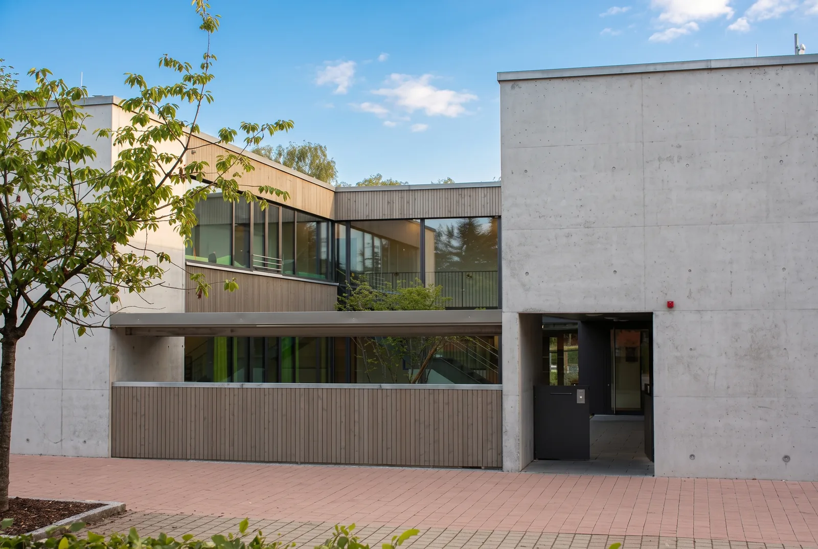 Eingang der Kita an der Köchlinstraße: Sichtbeton, Holzlamellen und ein Fensterband